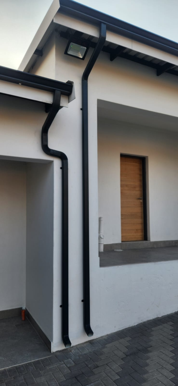 Completed gutter installation viewed along the length of the roof